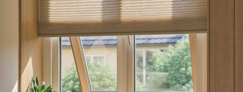 Plissee am Wohnzimmerfenster halb geschlossen — Sonnenschutz nach Mass von Bruderer Wohnen, Bodenseeregion